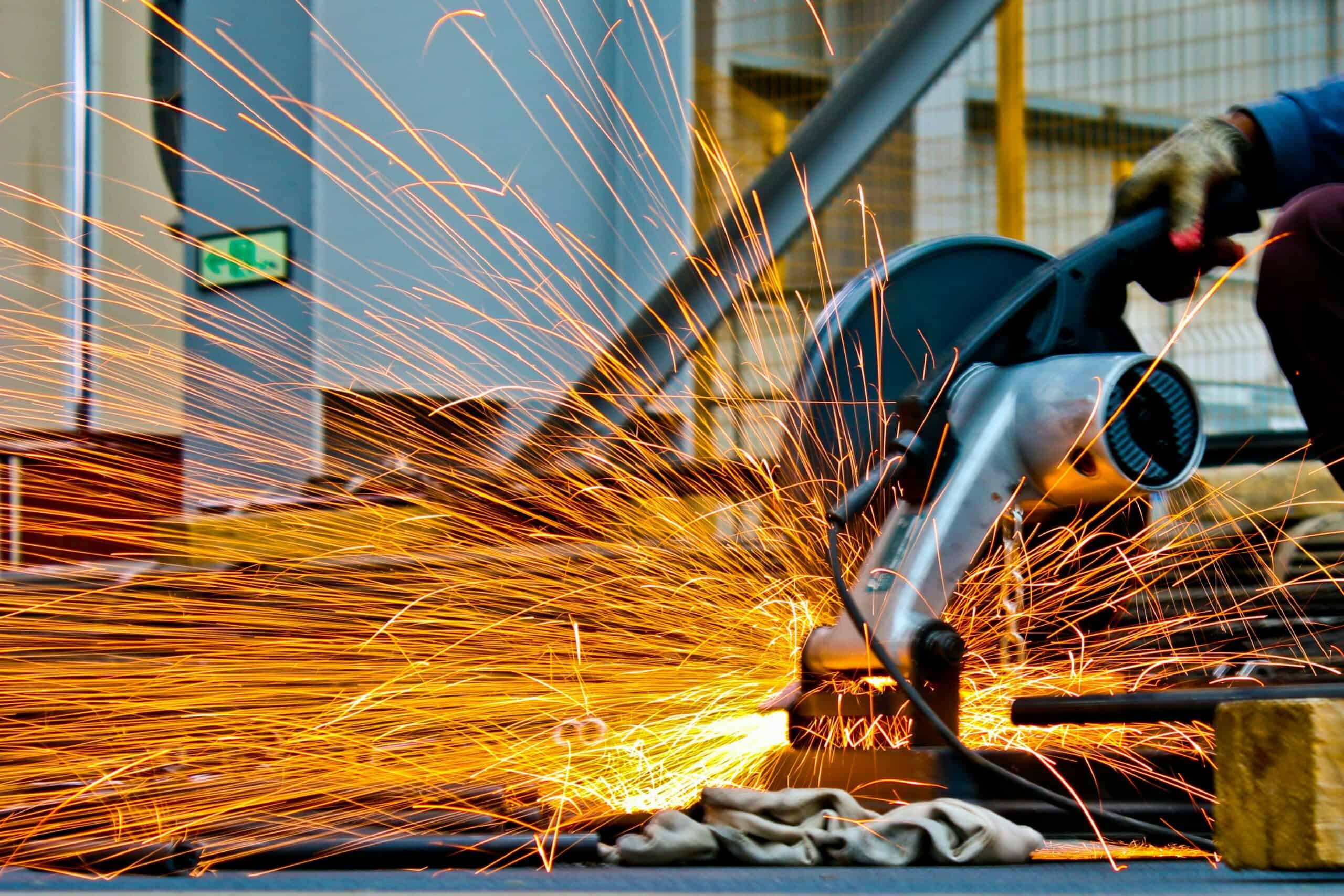 Workers' Compensation Insurance protects workers in dangerous job settings, such as sparks flying from a saw cutting metal.